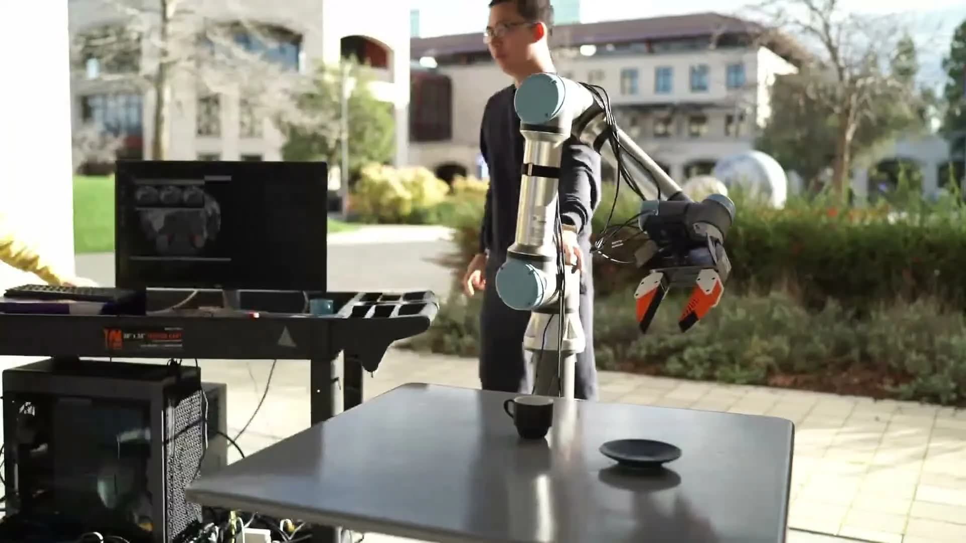 UMI robot learning experiment with a camera-equipped gripper, cup and saucer
